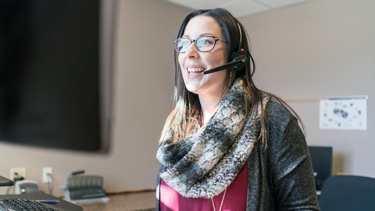 Friendly front desk staff speaking to a member on the phone.