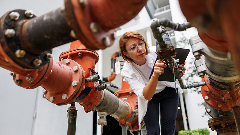 person inspecting industrial pipes