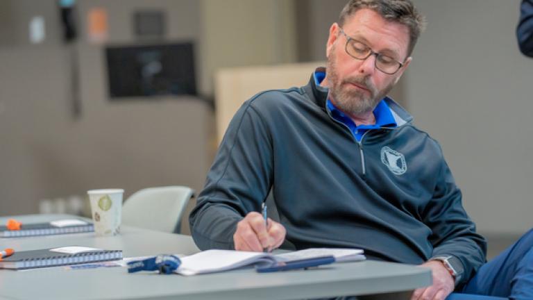 male writing in book