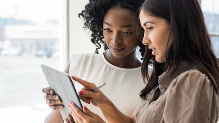 Two women holding tablet