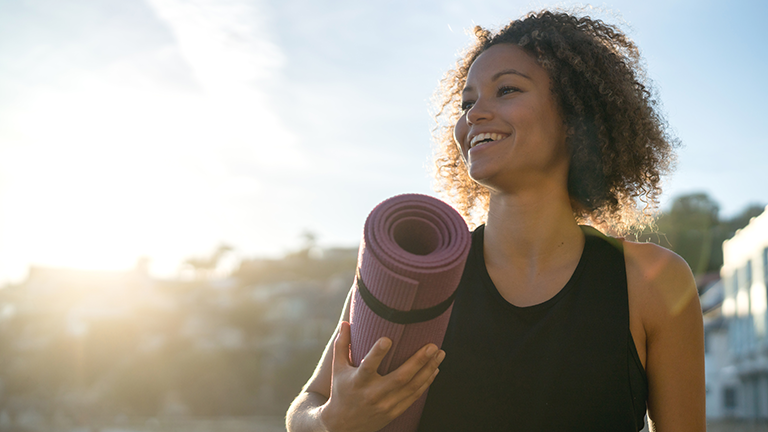 Woman enjoying outside with a yoga mat